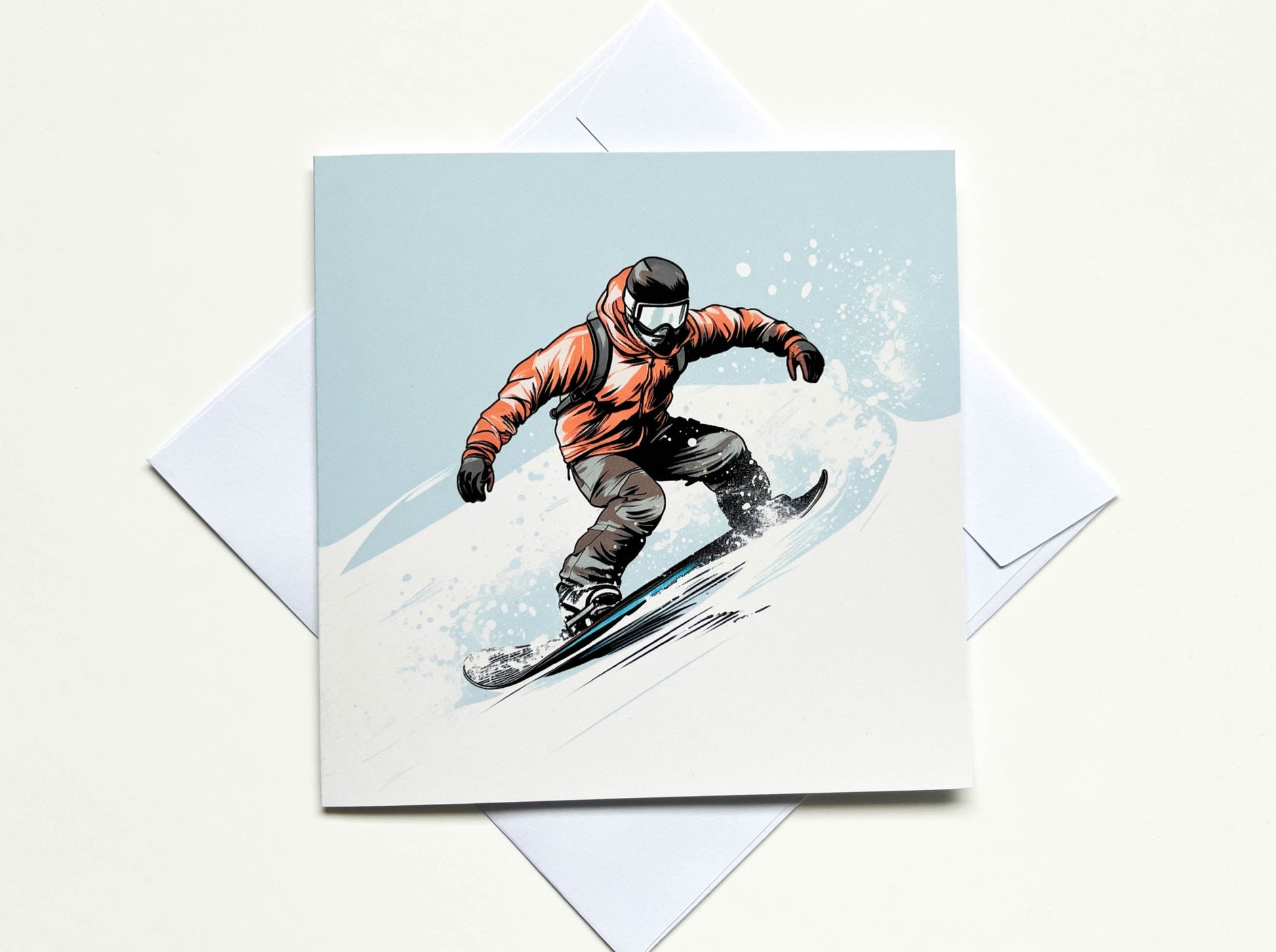 Greetings card showing a minimalist illustration of a man wearing a red jacket and black trousers snowboarding down a mountain with snow spray coming from his snowboard.  